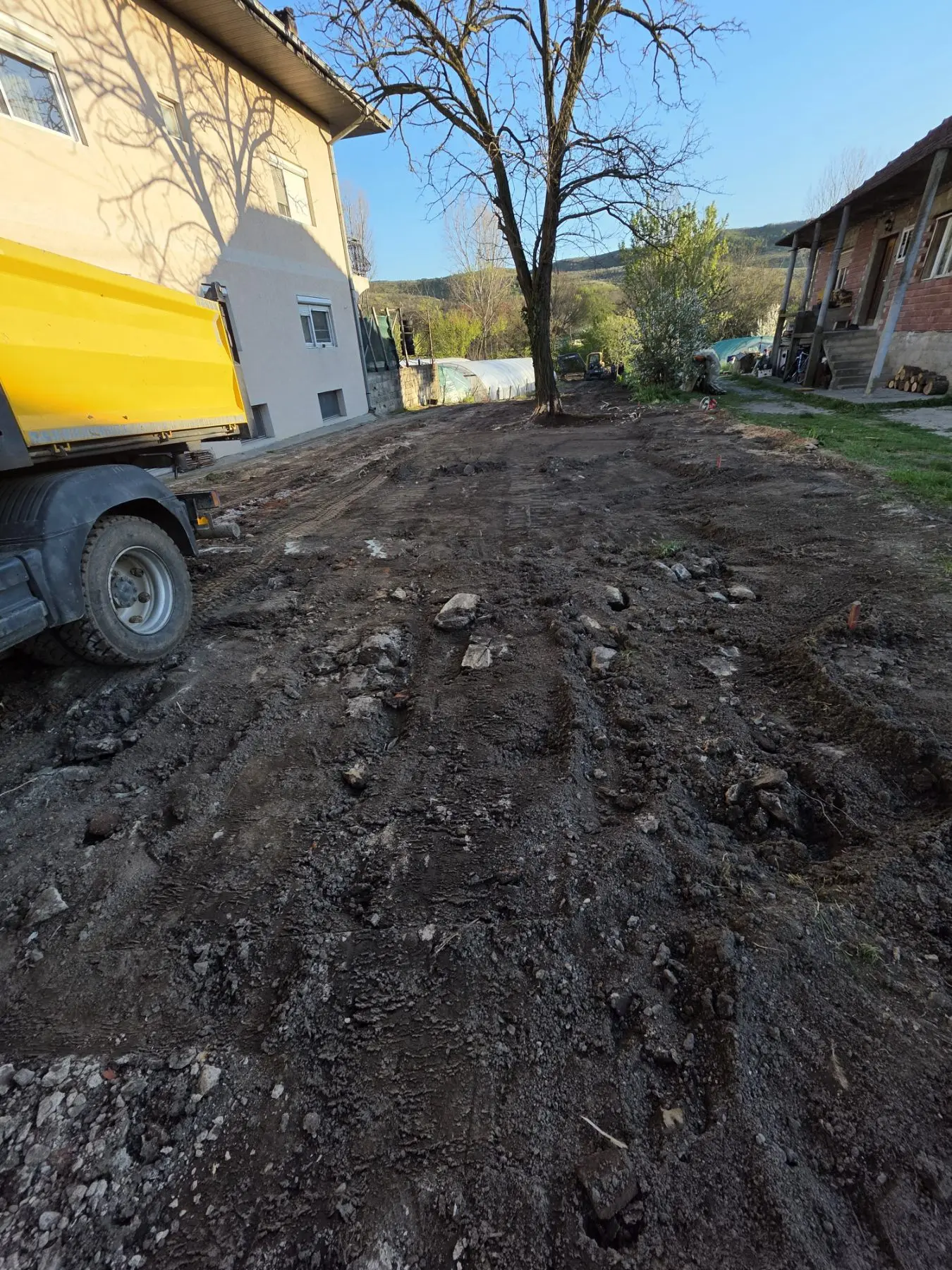 Kiper na utovaru zemlje i šuta u dvorištu