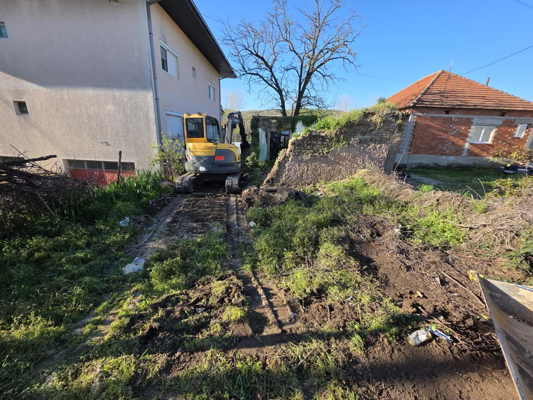 Bager uz stari zid tokom rušenja i raščišćavanja