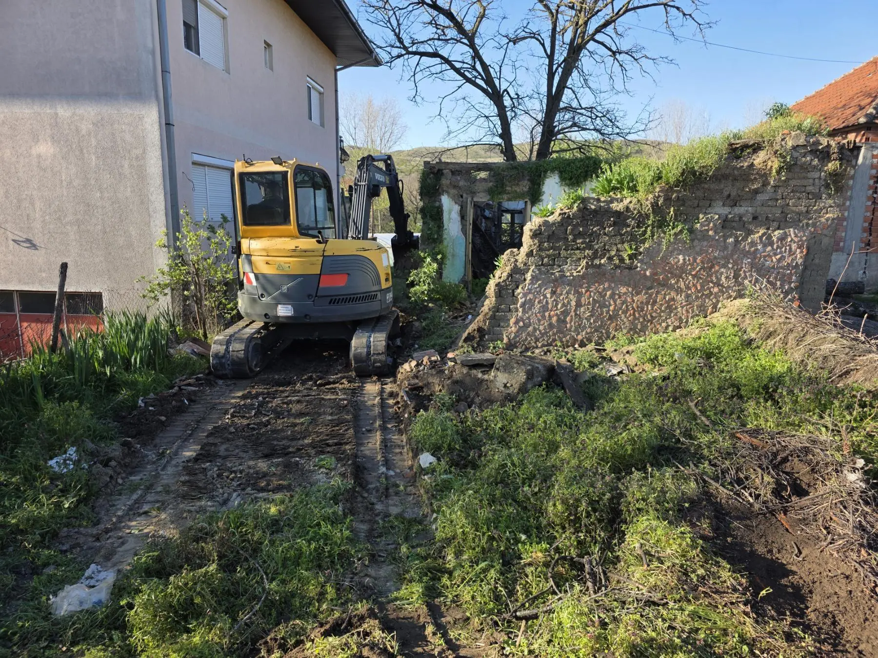 Bager kod starog zida pripremljenog za rušenje